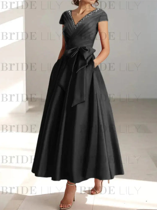 Black satin tea length dress with a tie bow