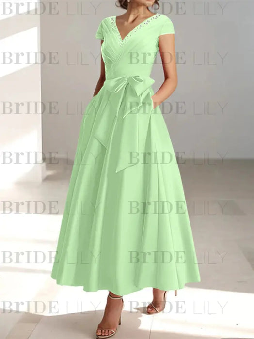 Celadon satin mother of the bride tea length dress with bow and pockets