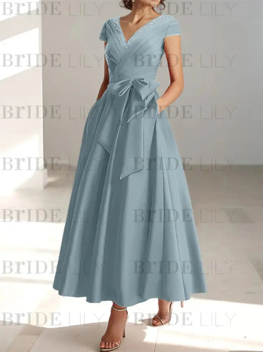 Dusty blue satin tea length dress with a tie bow