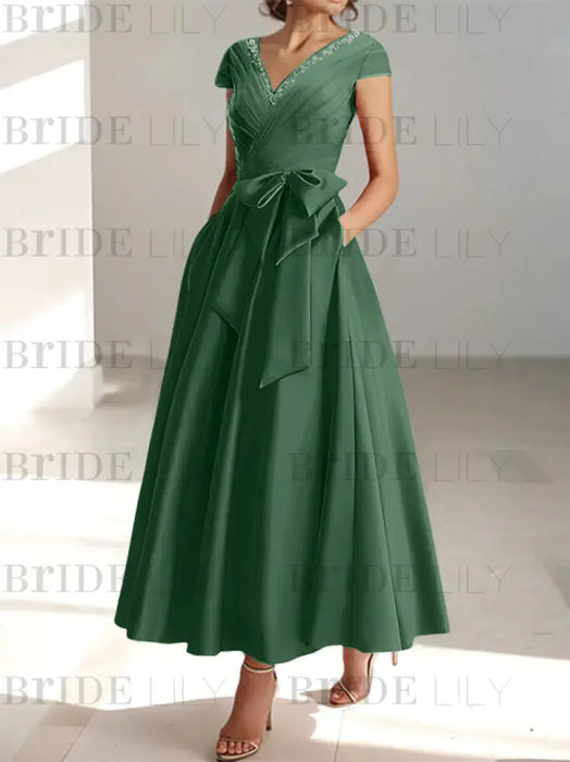 Sage green satin tea length dress with a tie bow