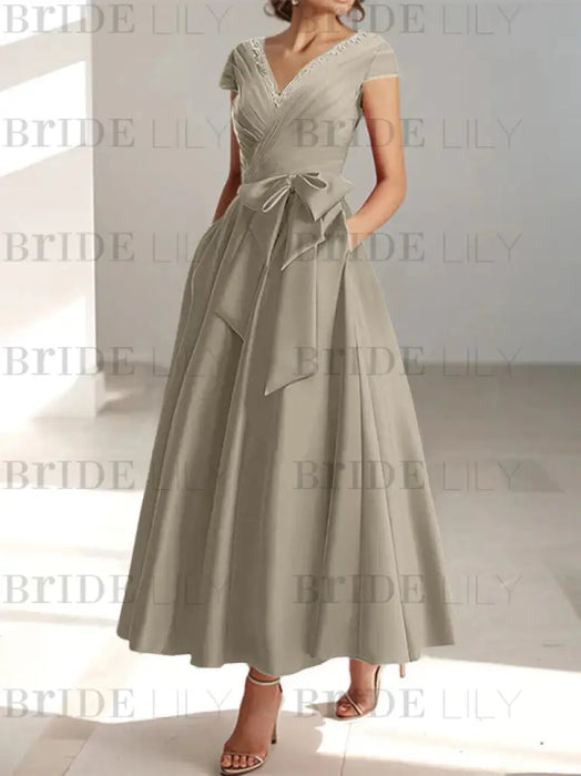 Taupe satin mother of the bride tea length dress with bow and pockets