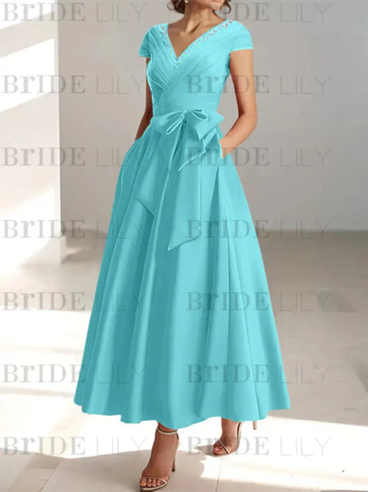 Turquoise satin tea length dress with a tie bow