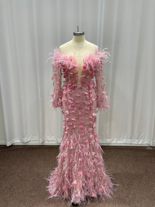 Pink feathered evening gown on a mannequin against a plain background