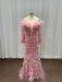 Pink feathered evening gown on a mannequin against a plain background