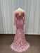 Pink evening gown with feathered details on a mannequin against a white curtain background.