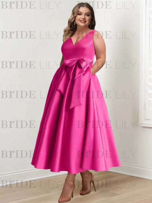 Fuchsia satin bow dress worn by a curve model