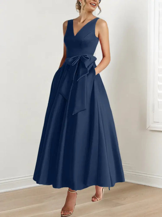 Navy satin ankle length dress with a bow sash and pockets