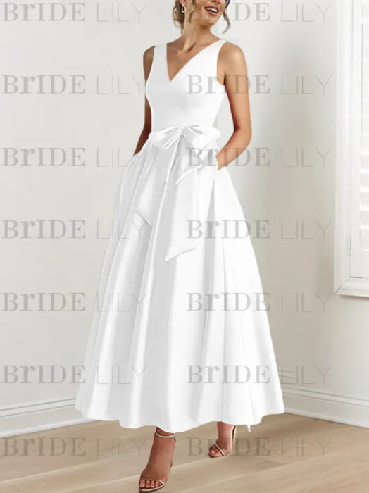 White satin ankle length dress with a bow sash