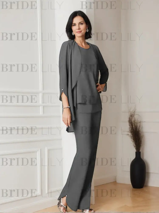 Grey chiffon three piece pantsuit worn indoors with the jacket open