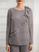 Close-up of crystal bar trim and ruffle on grey chiffon top