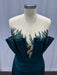 Teal dress with floral embellishments on a mannequin against a plain background
