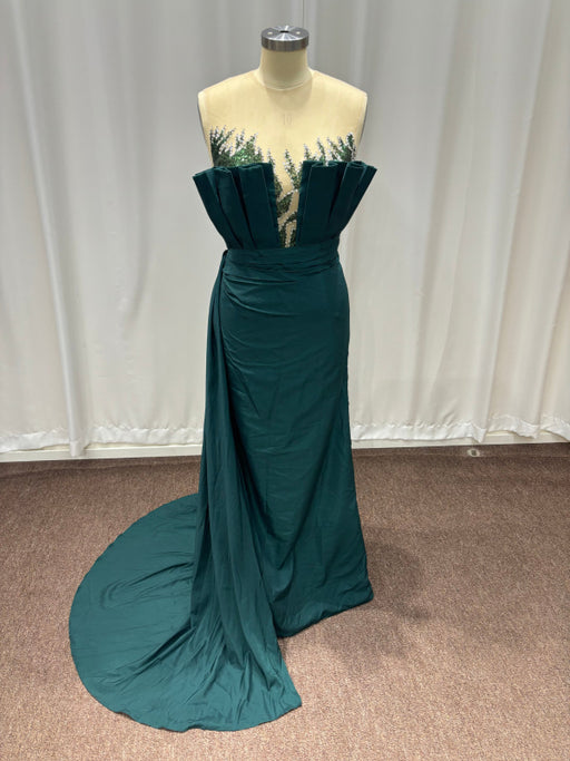Teal evening gown on a mannequin against a white curtain background