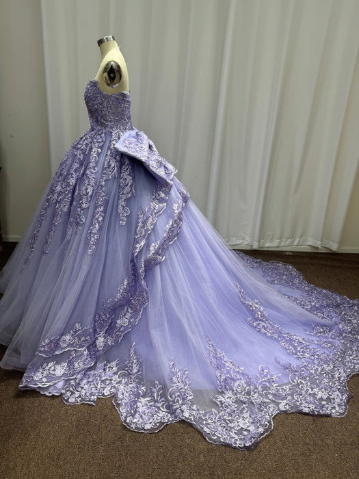 Lavender ball gown with intricate lace details on a mannequin against a plain background.