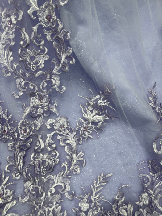 Embroidered fabric with intricate floral patterns on a sheer background