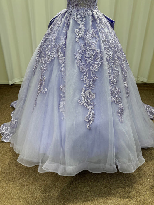 Elegant purple and white gown with intricate lace details on a plain background