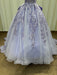 Elegant purple and white gown with intricate lace details on a plain background