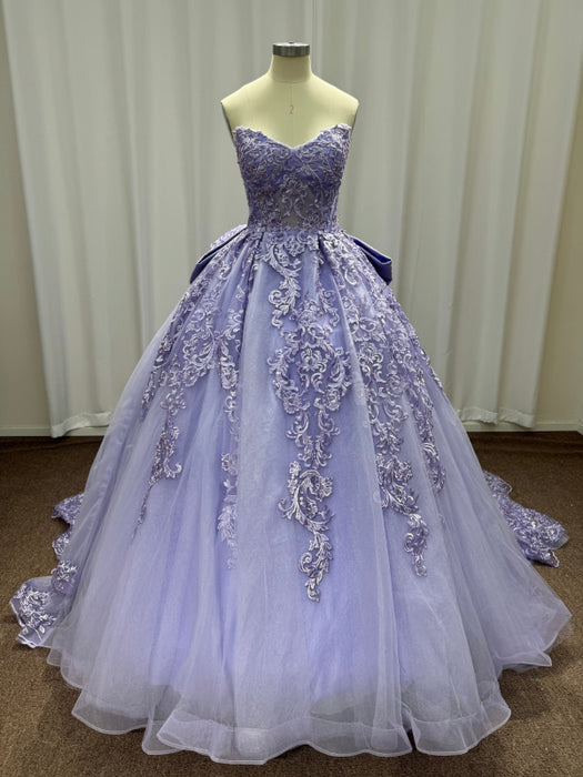 Lavender evening gown with floral embellishments on a mannequin against a plain background